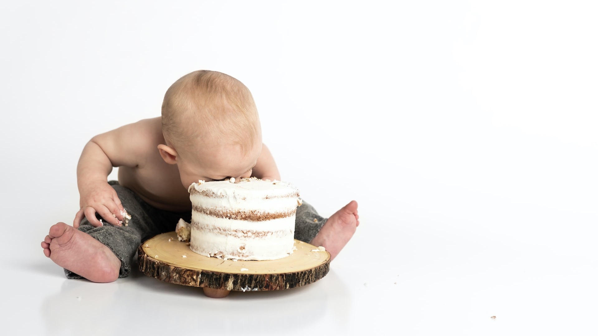 kid sitting beside round cake close-up photography